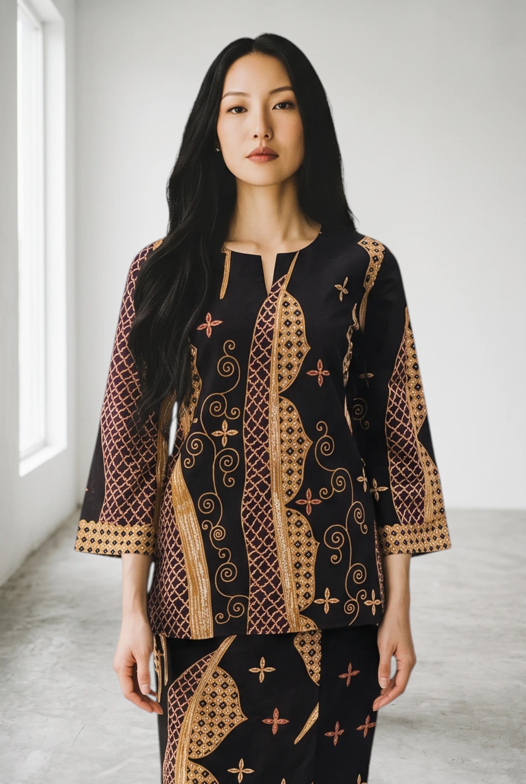 Model wearing a PARCA black cotton top and matching maxi sarung with traditional batik-inspired patterns.