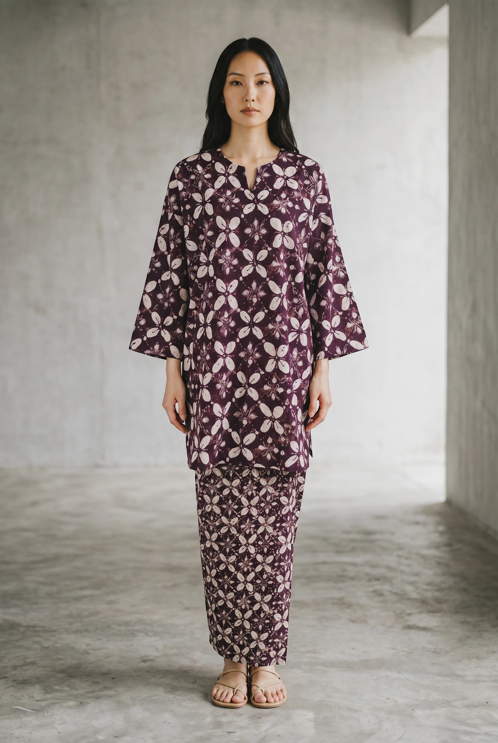 Model wearing a PARCA purple cotton midi top and matching maxi sarung with a floral batik-inspired print.