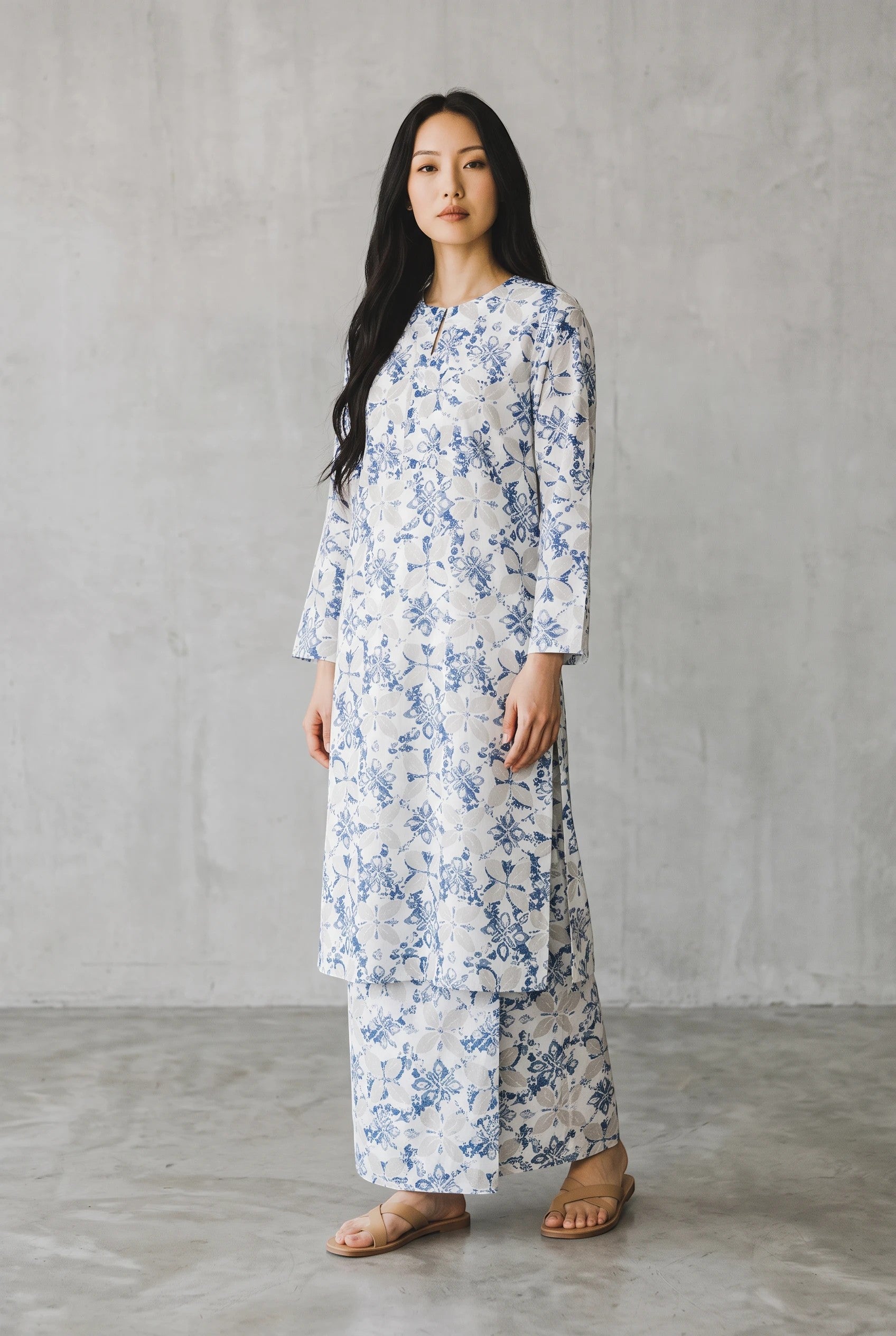 PARCA Naima white midi top and matching sarung set with blue floral print, worn by a model in a studio setting.
