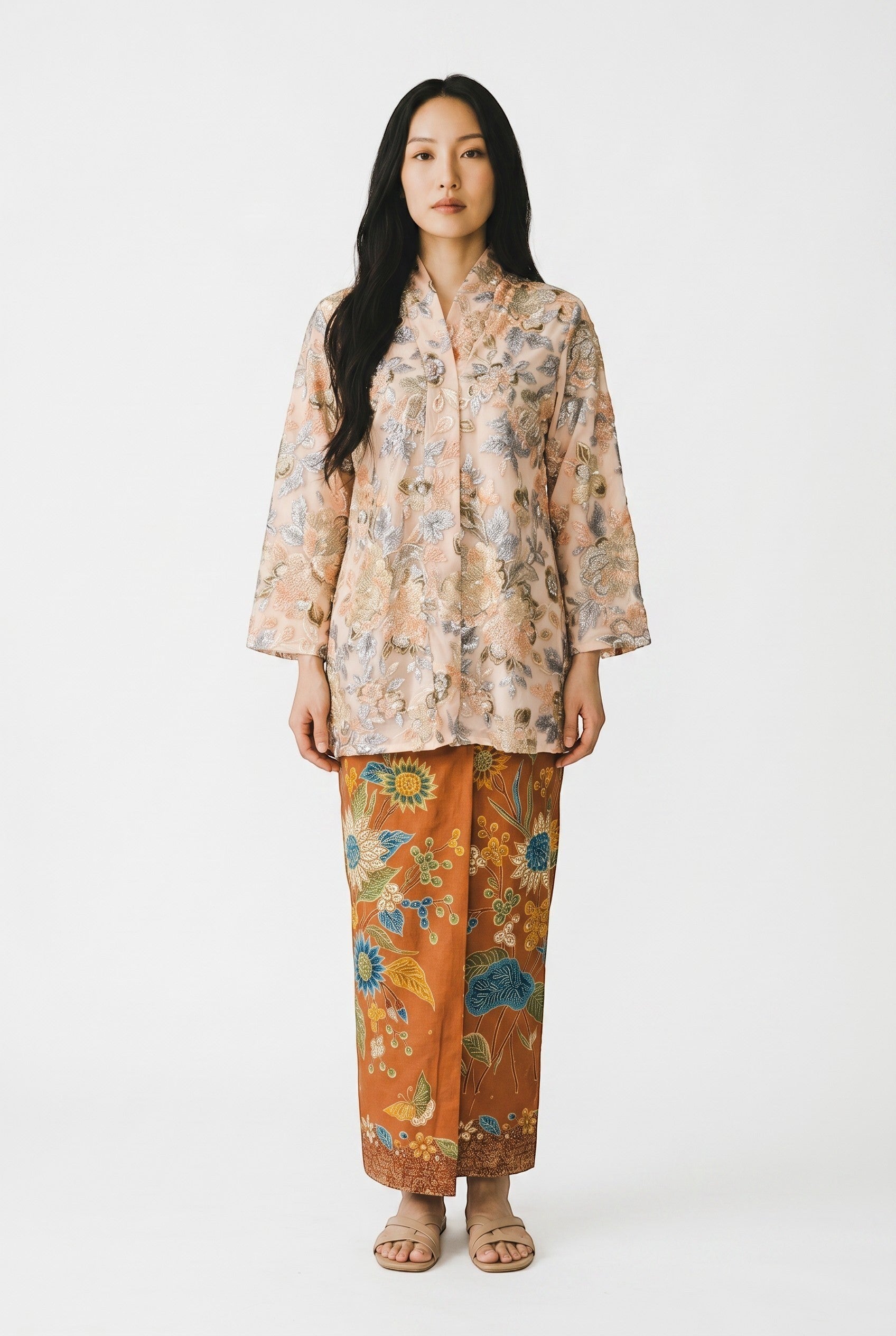 PARCA Naira Kimono Kebaya: Peach floral embroidered sheer top with bell sleeves paired with a brown batik sarong skirt.