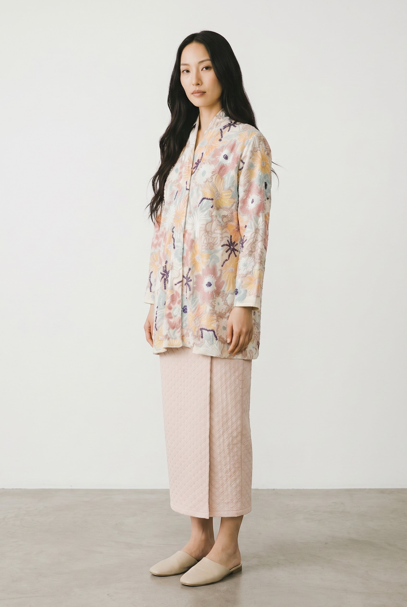 PARCA Naira Kimono kebaya in white with colourful floral embroidery and a pale pink textured skirt.