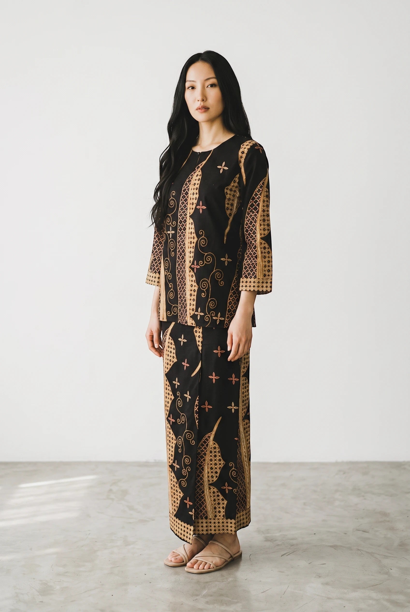 Model wearing a PARCA dark blue and tan batik print cotton top and matching maxi sarung skirt