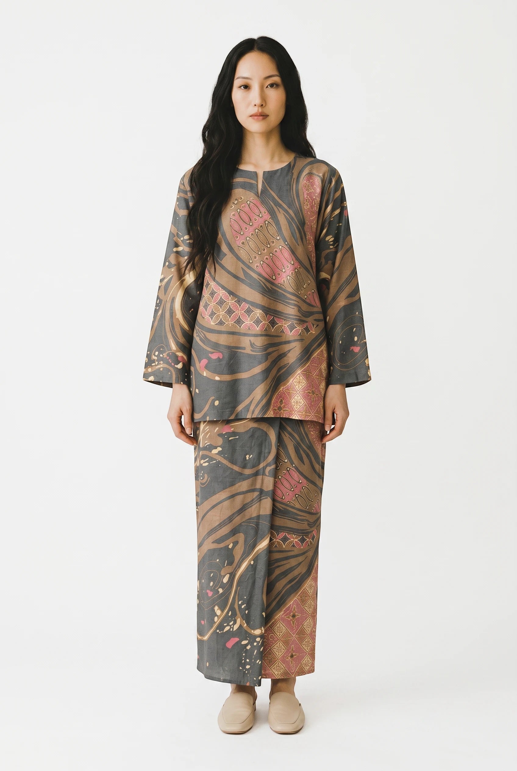 Model wearing a PARCA Natalia in Pink batik-style long-sleeved top and matching skirt with grey and pink patterns.